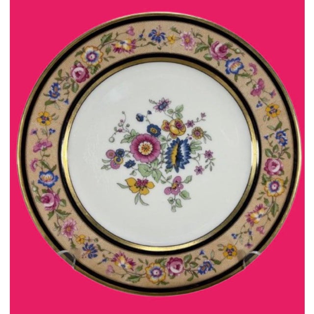 A collection of twelve antique French porcelain dishes featuring polychrome floral decoration at the center and along the...