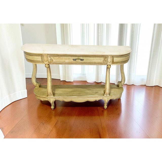 Elegant vintage Weiman console table featuring a beautiful marble top and classic Hollywood Regency styling. A timeless...
