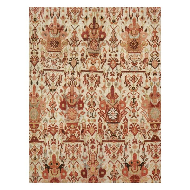This early 20th-century Persian Malayer carpet presents a finely organized allover floral composition across a warm ivory...