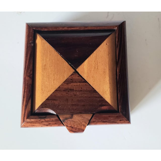 A compact mid-century jewelry box crafted from cocobolo and mixed hardwood inlays, perfect as a decorative accent or...