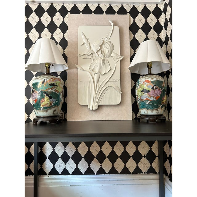 Large sculptural botanical wall relief depicting a single iris in a monochromatic ivory-white palette. The deeply modeled...
